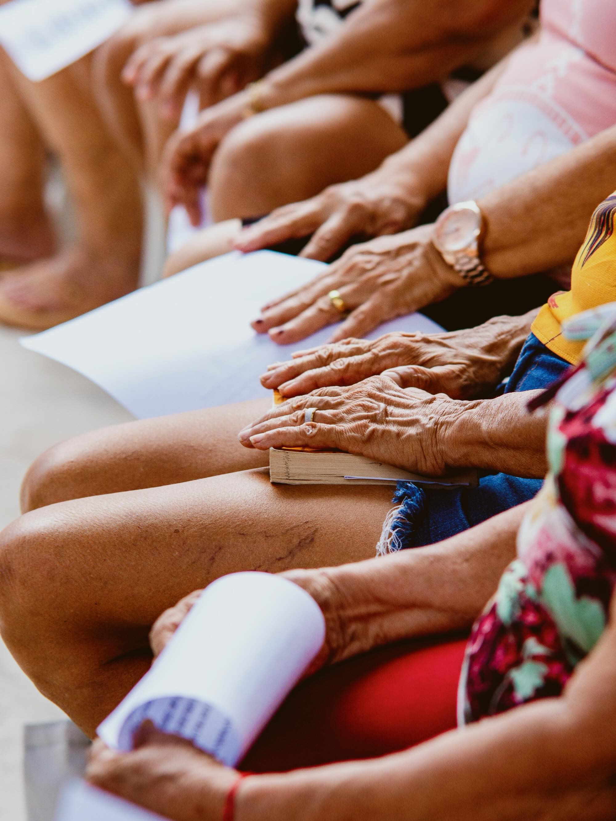 Detalhe das mãos das participantes durante uma atividade em grupo