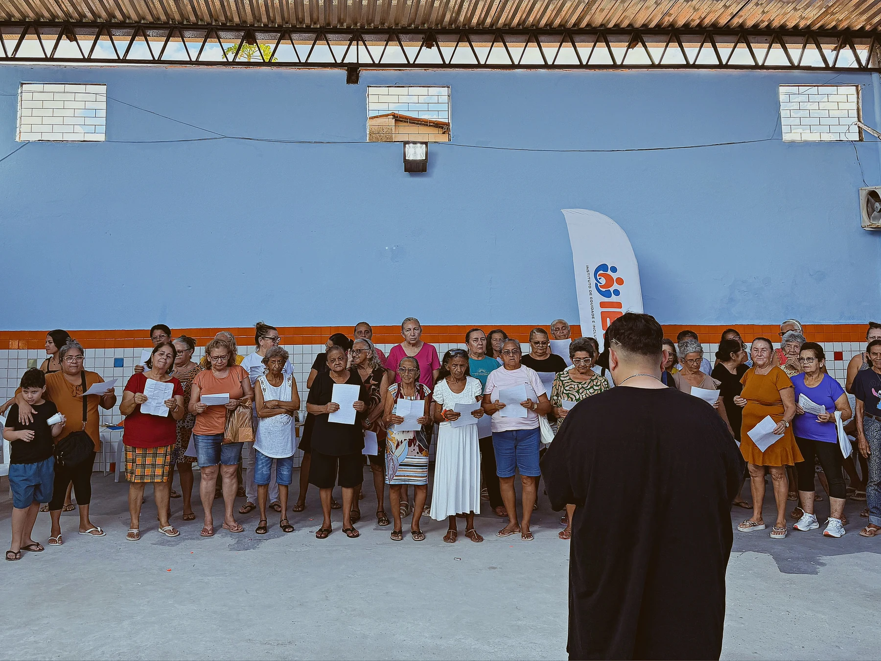Ensaio coletivo com acompanhamento de regência e apoio das letras impressas, articulando escuta, ritmo e participação · 2026