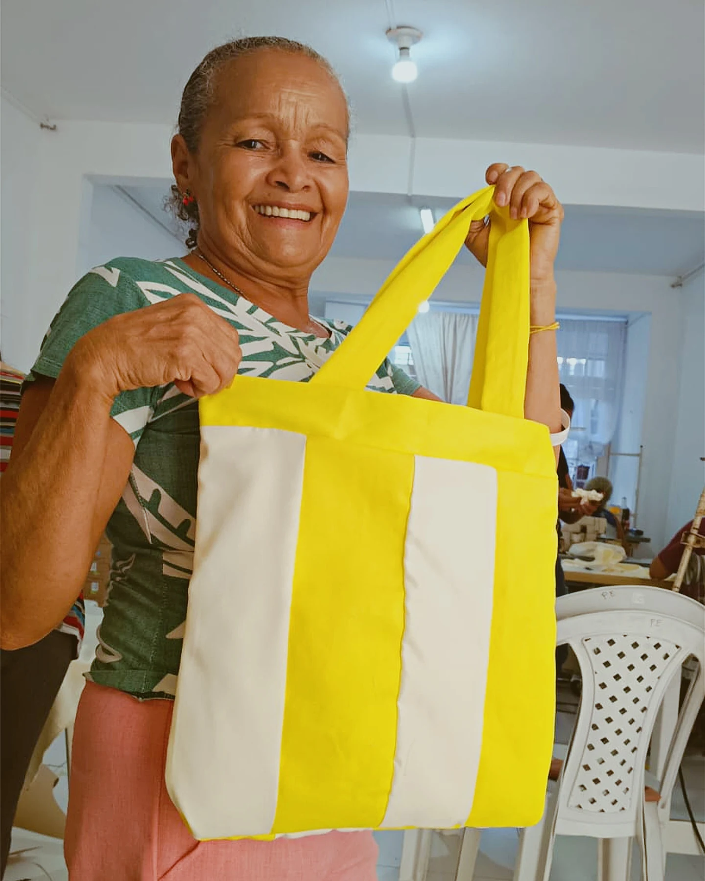 Participante apresenta a bolsa de tecido produzida na atividade de costura, dando visibilidade ao aprendizado e à criação de uma peça utilitária · 2026