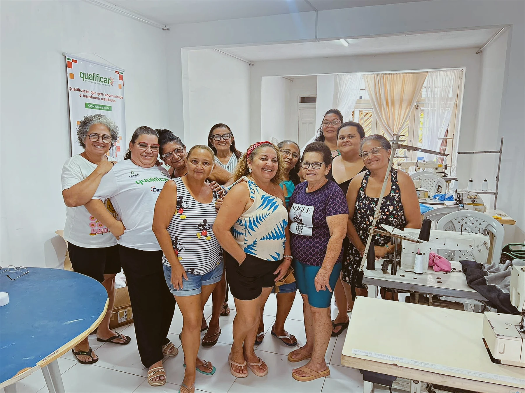 Turma reunida no ambiente das aulas, com máquinas de costura e materiais que apoiam a aprendizagem coletiva · 2026