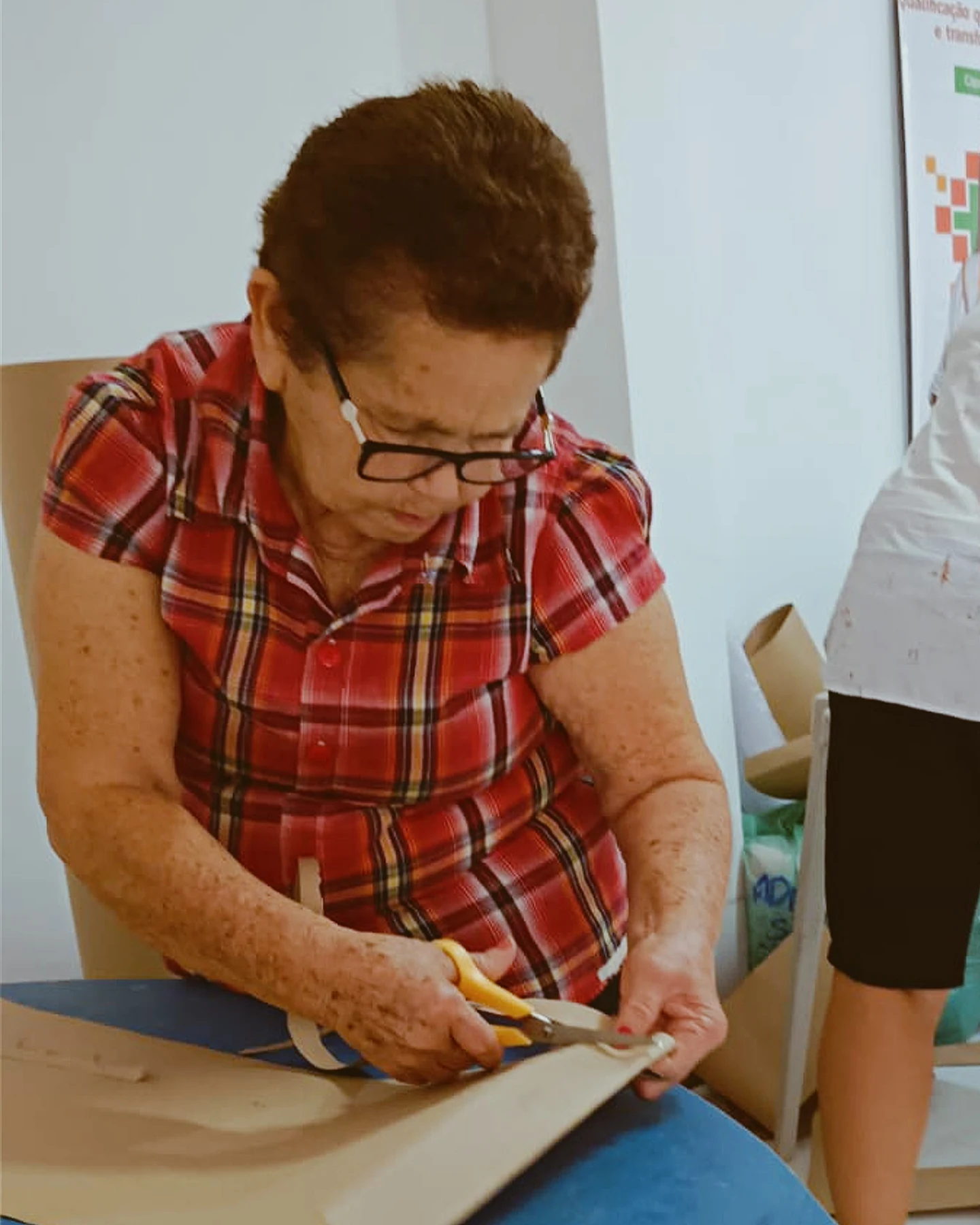 Corte do tecido com tesoura durante a preparação de uma peça, registrando uma etapa prática do trabalho de costura · 2026